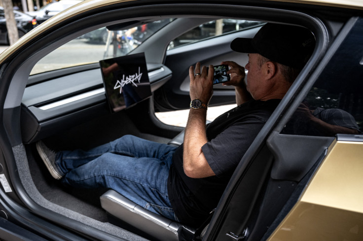 A man takes a photo inside a Tesla's "Cybercab" as
